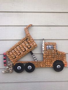 a metal truck made out of bottles on the side of a building