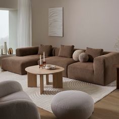 a living room with couches, chairs and a table in front of a window