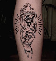 a black and white tattoo on the leg of a person with a hand holding an object