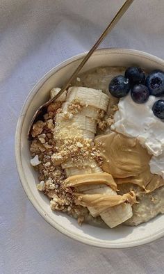 a bowl filled with oatmeal and blueberries on top of a white cloth