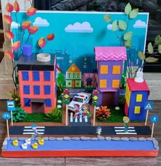 a paper model of a city with cars and houses on the street next to a fire hydrant