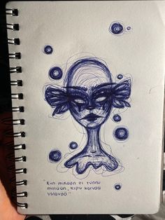 a drawing of a woman's face in blue ink with words written below it