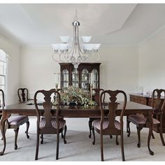 a dining room table with chairs and a chandelier