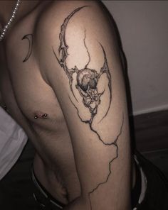 a man's arm with a skull and moon tattoo on the left side of his body