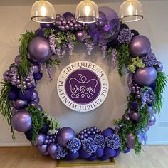 a circular wreath with purple ornaments and greenery on the bottom, in front of a sign for the queen's diamond jubilee