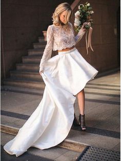 a woman is walking down the stairs wearing a white skirt and crop top with high heels