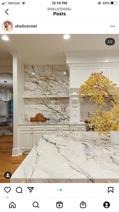 a kitchen with white cabinets and marble counter tops on instagramting from the app