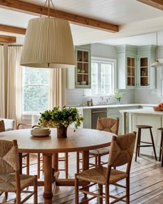 a dining room table with chairs around it and an island in the middle of the room