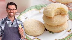 a man standing next to a plate with three donuts on it and a glass of milk in the background