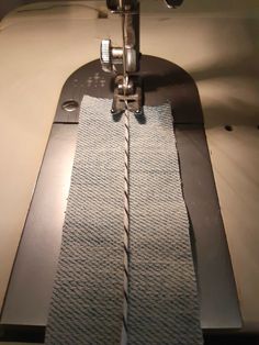 a close up of a sewing machine with a piece of fabric on it's side