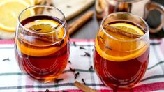 two glasses filled with tea and orange slices