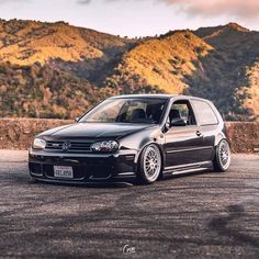 a black car parked in front of a mountain