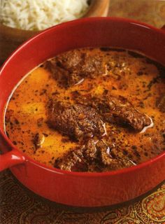 a red bowl filled with meat and rice