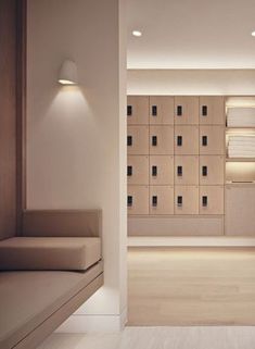 an empty room with several lockers on the wall and two benches in front of them