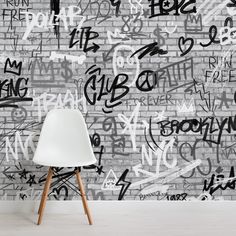 a white chair sitting in front of a wall with graffiti on it