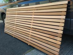 a large wooden slatted fence sitting next to a car