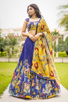 Blue attached cancan lehenga with animal and bird kalamkari hand painted patterns. Paired with  padded blue blouse embroidered with glass beads and kalamkari yellow dupatta with contrast border. - Aza Fashions Yellow And Blue Lehenga, Saree Chaniya Choli Style, Kalamkari Lehangas Designs, Kalamkari Tops Designs, Royal Blue Dupatta For Navratri, Semi-stitched Blue Lehenga With Motifs, Designer Blue Lehenga With Motifs, Fitted Royal Blue Lehenga For Navratri, Blue Wedding Dress With Motifs