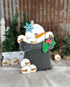 a snowman and two ducklings in front of a christmas tree