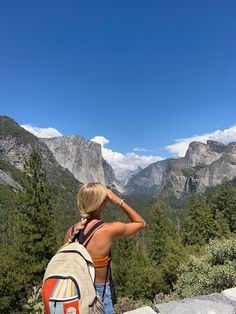 a woman with a backpack looking at the mountains and valleys in yose peak, yose