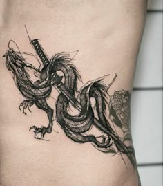 a black and white photo of a dragon tattoo on the side of a man's stomach