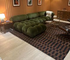 a large green couch sitting on top of a rug in a living room