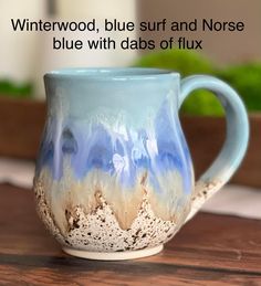 a blue and white mug sitting on top of a wooden table