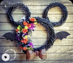 a mickey mouse wreath with flowers and bats