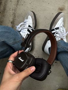 someone is holding their headphones in front of the person's legs and feet