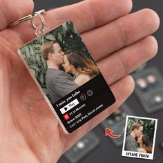 a hand holding a keychain with an image of a couple kissing on it