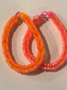 two orange and pink bracelets sitting next to each other