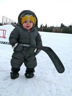 a small child is standing in the snow holding a tire while wearing skis on his feet