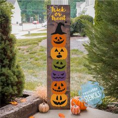 a wooden sign with carved pumpkins on it