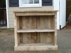 a wooden shelf sitting in front of a house