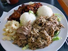 a white plate topped with meat, rice and veggies next to a fork