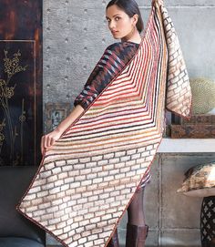 a woman standing in front of a fireplace holding a blanket