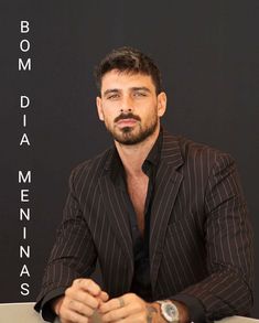 a man sitting at a table in front of a sign