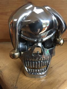 a metal skull head sitting on top of a wooden table