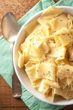 a white bowl filled with pasta on top of a green napkin