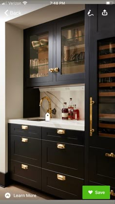 a kitchen with black cabinets and gold handles