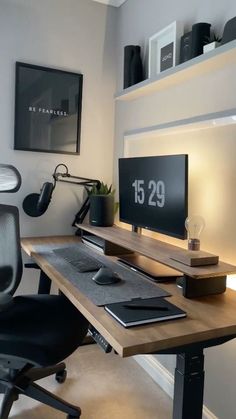 a desk with a monitor, keyboard and mouse on it next to a black chair