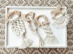 three wooden toys with tassels on top of a white tray next to a rug