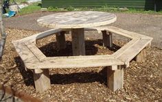 a wooden picnic table sitting on top of a pile of mulch