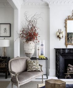 a living room filled with furniture and a large flower vase on top of a table