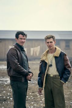 two men standing next to each other in the dirt