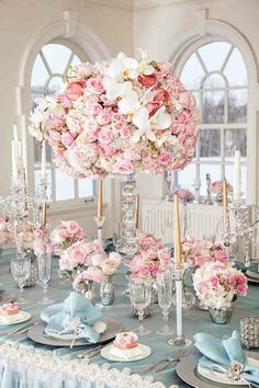 the table is set with pink and white flowers