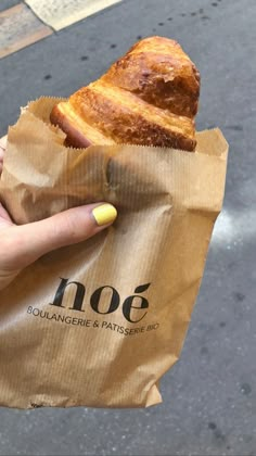 a person holding a bag with some food in it