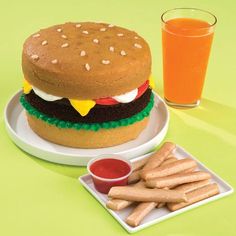 a hamburger and fries on a plate next to a glass of orange juice