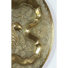 a gold plate with a snake on it's side and an intricately designed design