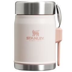 the stanley coffee mug has a spoon in it and is white with pink trimmings