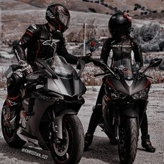 two people in leathers are sitting on motorcycles